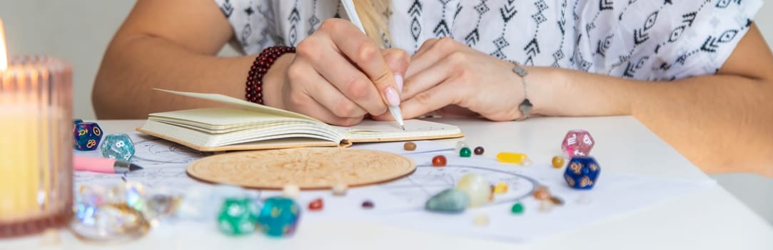 Woman astrologer draws a natal chart. Selective focus.
