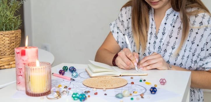 Woman astrologer draws a natal chart. Selective focus.