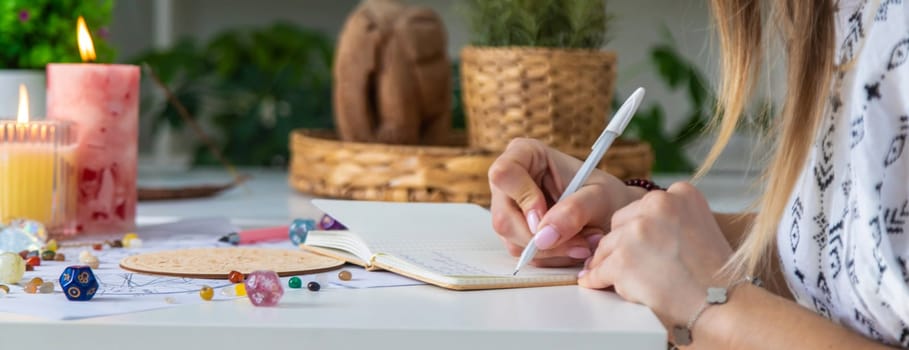 Woman astrologer draws a natal chart. Selective focus.