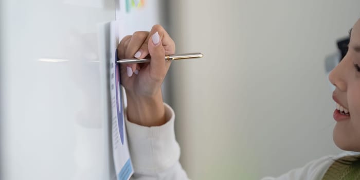 A finance expert writes notes on a whiteboard to outline tax strategies and financial analysis.