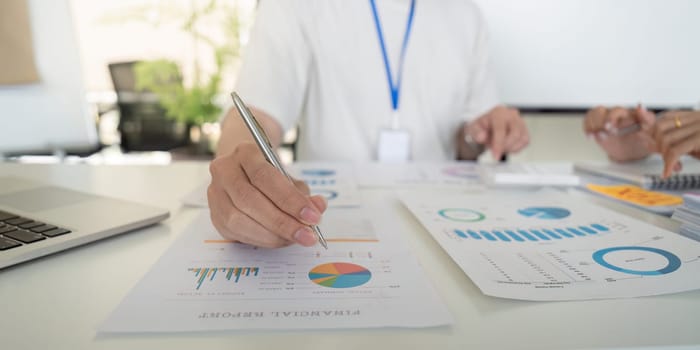 Professionals engage in financial report analysis, focusing on tax deduction strategies and data interpretation through charts.