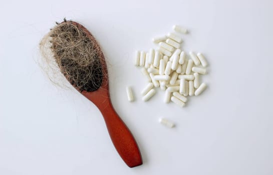 hair brush with hair and vitamins. hair loss.