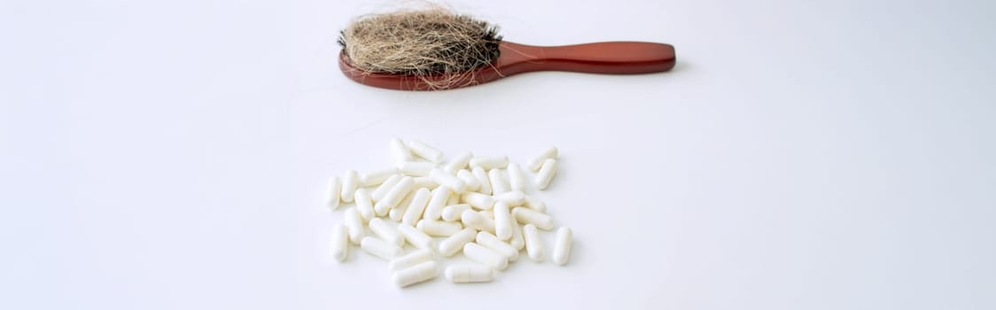 hair brush with hair and vitamins. hair loss.