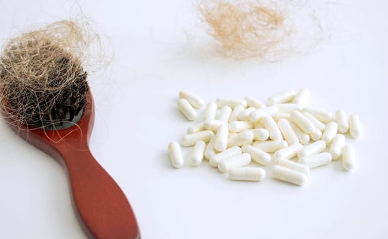 hair brush with hair and vitamins. hair loss.