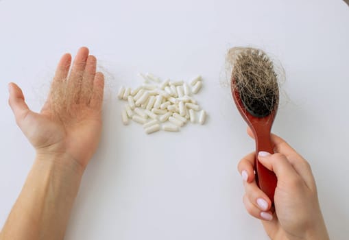 hair brush with hair and vitamins. hair loss.