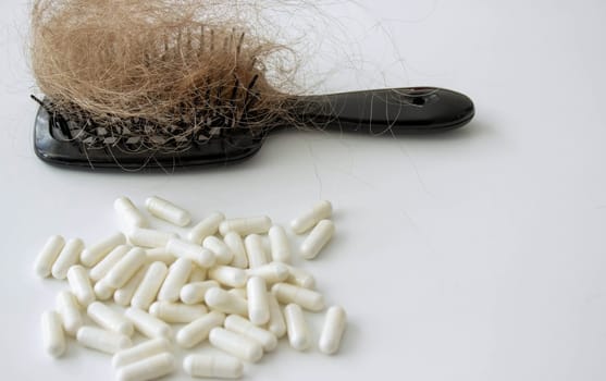 hair brush with hair and vitamins. hair loss.