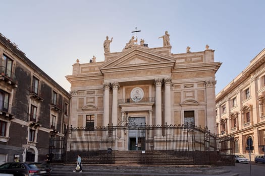 Catania. Italy - March 3, 2025: Elegant San Biagio Church featuring ornate details and statues against Catania's skyline. Great for history, tourism, and religious site photography in bright daylight.