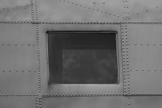 A square shaped porthole in an old military plane. aircraft's eluminators. windows of airplane.