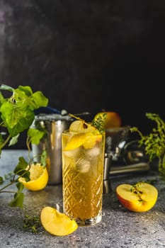 Chilled apple cocktail featuring a garnish of juicy grapes, a twist of lemon, and a sprig of thyme, creating an elegant refreshment
