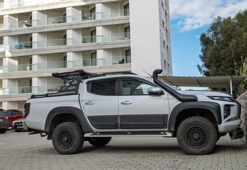 Gaziveren Cyprus -28.02.2025 A sleek customized pickup truck is parked alongside a contemporary apartment complex, showcasing its rugged features.