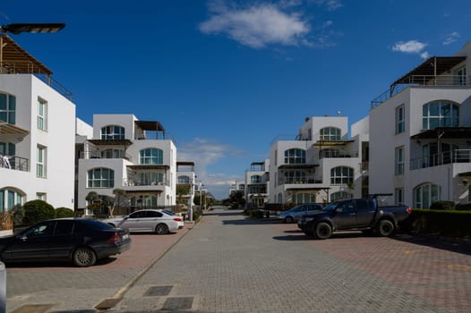 Sunlight brightens chic villas lining a calm street, fostering a peaceful neighborhood vibe.