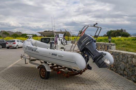 Gaziveren Cyprus -01.03.2025 A sleek inflatable boat rests on a trailer in a parking area, ready for exploration as clouds loom above.