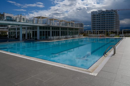 Reflections dance on the calm water as visitors enjoy the serene pool atmosphere in a modern setting.