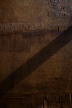 Soft light casts a long shadow on rugged wood, revealing the natural beauty of the grain and creating a peaceful vibe.