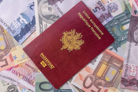 International passport of a citizen of France on background of paper banknotes of different countries
