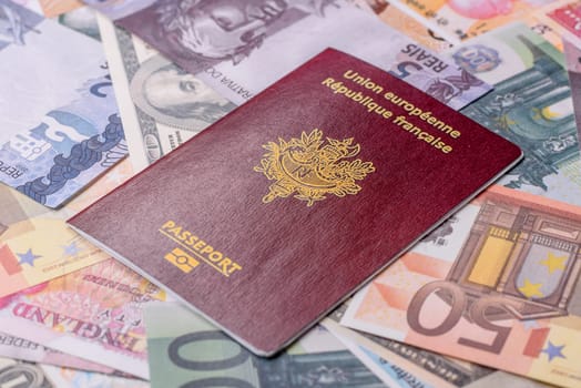 International passport of a citizen of France on background of paper banknotes of different countries