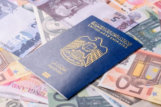 International passport of a citizen of United Arab Emirates against the paper banknotes