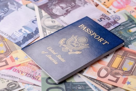 International passport of a citizen of USA on a against the background of paper banknotes of different countries