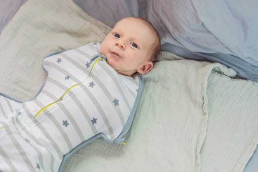 A newborn baby rests snugly in a cozy sleep cocoon, feeling secure and comforted before drifting off to sleep. A peaceful moment of relaxation, warmth, and gentle care, symbolizing restful sleep and early childhood.