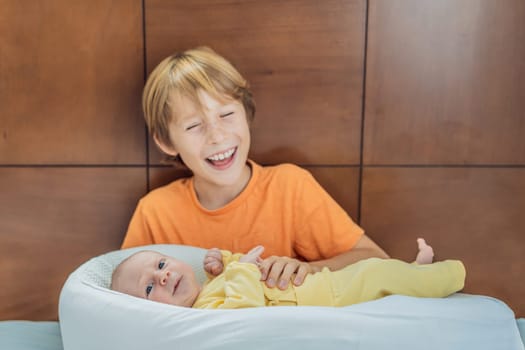 A young boy lovingly holds his newborn brother in a cozy sleep cocoon, sharing a tender sibling moment. A heartwarming scene of family bonding, protection, and the start of a lifelong brotherly connection.