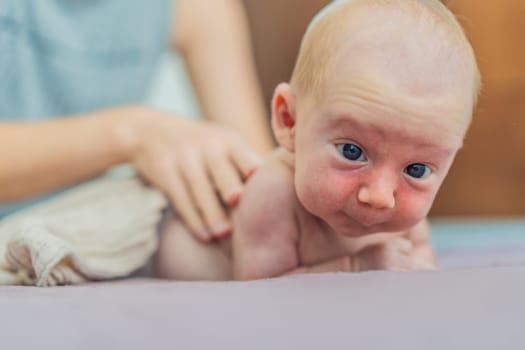 A mother gently massages her 1-month-old baby with baby oil after a bath. This tender moment highlights the bond between parent and child, promoting relaxation, baby care, and the importance of skin-to-skin contact.