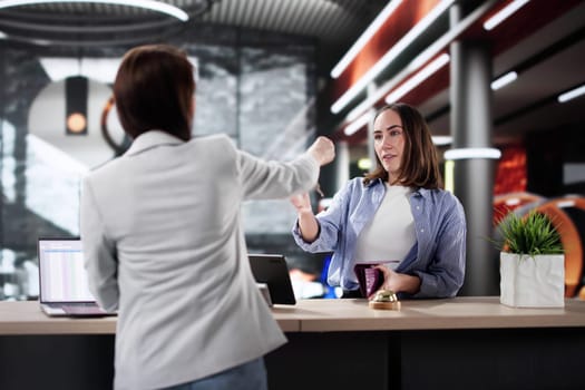 Professional Woman Discussing Reservation with Hotel Receptionist, Business Trip Lifestyle