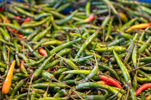 Vibrant green and red chili peppers at a farmers market. Perfect for food photography, spice lovers, culinary ingredients, hot sauces, and fresh organic produce.