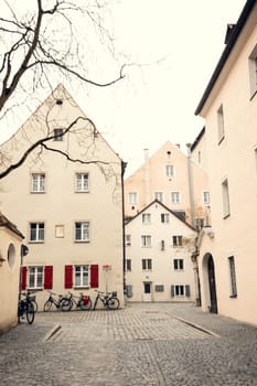 Quiet European courtyard with historic buildings and parked bicycles, evoking a nostalgic old-town charm. Parked bicycles along the cobblestone street enhance the peaceful cityscape