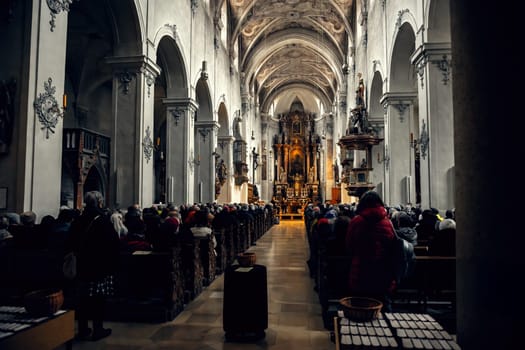 A grand historical church filled with worshippers. The intricate ceiling and detailed architecture create a spiritual atmosphere. Perfect for religious, historical, or cultural themes.