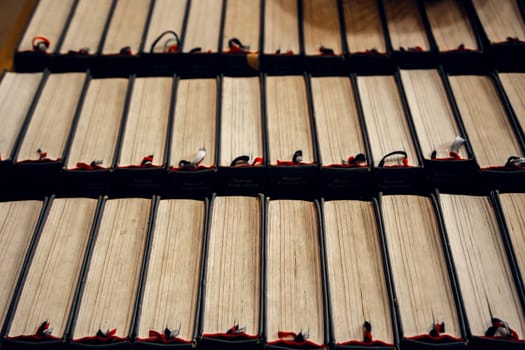 A row of antique books with worn pages and ribbon bookmarks in a historical library. Perfect for themes of literature, knowledge, history, and classical education.