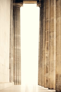 Majestic classical columns in a historic building. Symmetric architectural perspective with soft light. ideal for cultural and architectural themes
