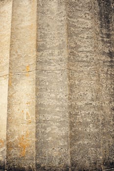 Old stone column showcasing vertical grooves and a rough, weathered texture. The aged surface and natural color variations make it ideal for backgrounds, architecture, and history-themed designs.