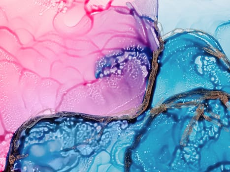 Alcohol ink fluid art. Waves in blue and pink colors with liquid golden inclusion. Abstract gradient background or texture