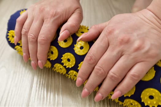 Women's palms on needle roller - foot massage using an applicator Kuznetsov, Russia