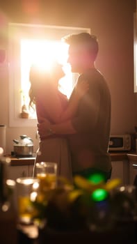 A married couple hugs in the morning in the kitchen. A man and a woman in love hugging each other in the rays of the morning sun. High quality photo