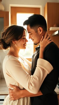 A married couple hugs in the morning in the kitchen. A man and a woman in love hugging each other in the rays of the morning sun. High quality photo