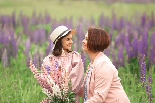 Mother and daughter enjoying time in lupine field.