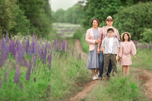 Caucasian family posing in flower field with parents and children enjoying nature.