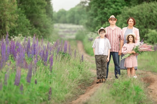 Caucasian family outdoors, posing in flowers field.