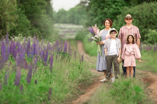 Happy family with flowers in scenic field pathway.