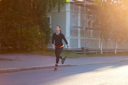 girl on roller skates riding at sunset , sport