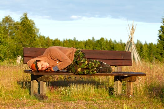 guy sleeps on a bench on the outskirts of the city, love and care