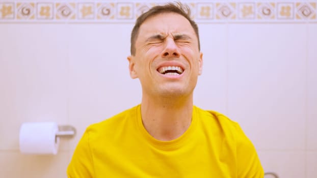 Man sitting on toilet and making an effort because of constipation