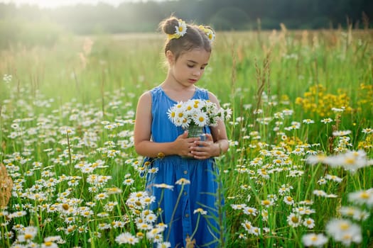 Cute little girl, holding a jar with a bouquet of daisies, in a field, on a sunny day