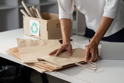 A person arranges paper bags on a table, illustrating the importance of recycling and sustainability in everyday activities.