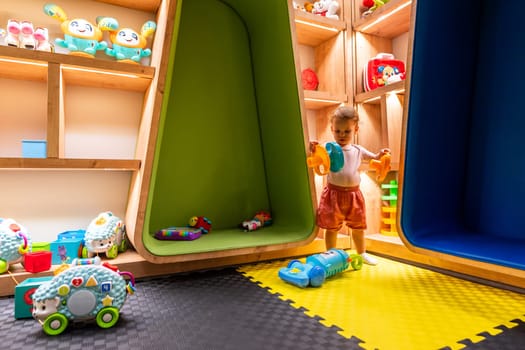 Child exploring toys and games in a vibrant and interactive indoor playroom for fun and learning