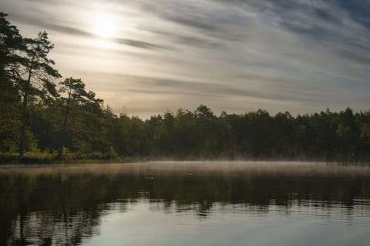Sunrise with fog forming over a lake in Sweden, at dawn. Romantic silence, in the Scandinavian nature
