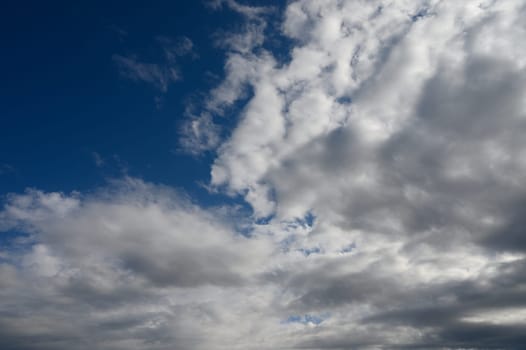 Fluffy white clouds dramatically contrast against a deep blue sky, creating a captivating natural masterpiece.