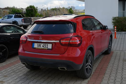 Gaziveren Cyprus -03.03.2025 A striking red SUV rests beside a sleek black vehicle, showcasing its contemporary design against a cloudy backdrop.