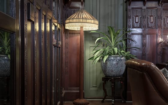 Bangkok, Thailand - Mar 02, 2025 - Vintage lamps, plants in antique ceramic pots and carved wooden cabinets inside the Drawing room at The main Bang Khun Phrom Palace that blends Art nouveau combined Art deco. use it as your Wallpaper, Poster and Space for text, Selective focus.